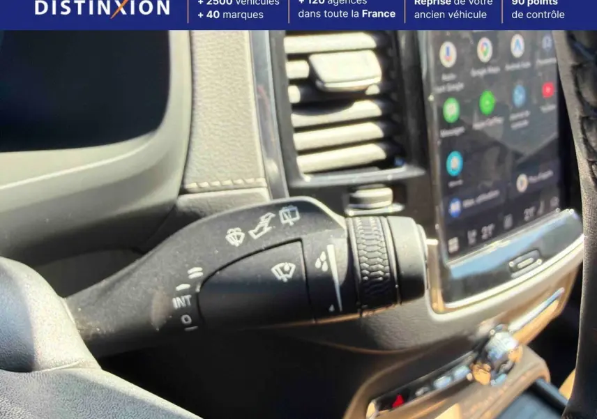 Gros plan sur la commande des essuie-glaces à gauche du volant dans l’habitacle d’un Volvo XC90 gris 2024.