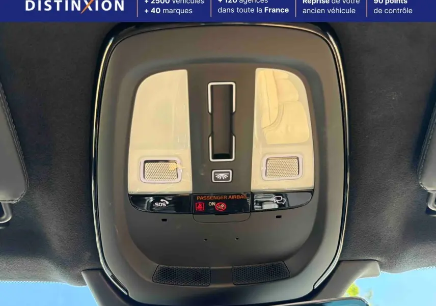 Vue en plongée du plafonnier intérieur gris du Volvo XC90 2024 avec boutons SOS et éclairage intégré.