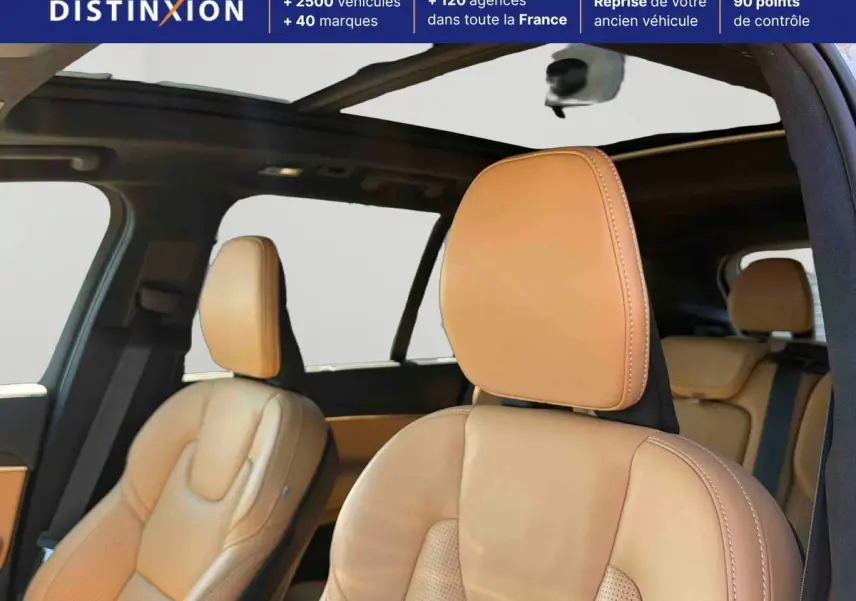 Vue intérieure du Volvo XC90 2024 montrant les sièges avant en cuir beige et le toit ouvrant panoramique.