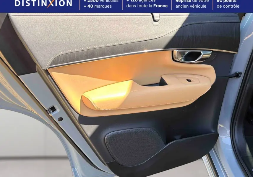Vue rapprochée de la porte avant gauche grise du Volvo XC90 avec garniture beige et insert chromé autour de la poignée.