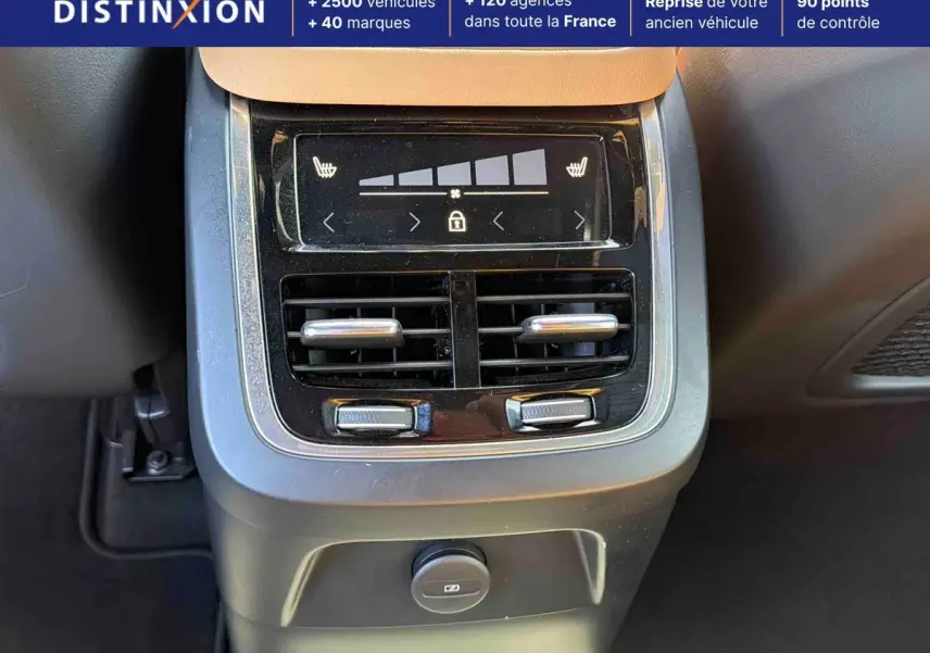 Détail de la console arrière avec commandes de climatisation et prises sur Volvo XC90 gris 2024.