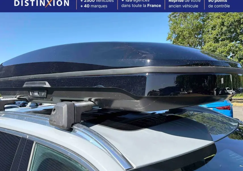 Vue rapprochée du coffre de toit noir sur barres de toit d’un Volvo XC90 gris 2024, côté gauche visible.