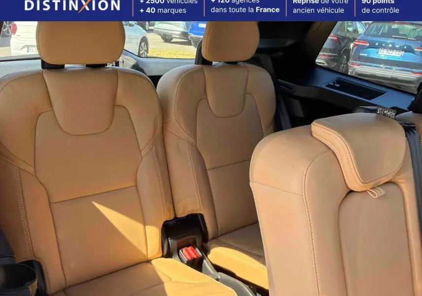Intérieur montrant la troisième rangée de sièges en cuir beige du Volvo XC90, avec vue arrière et fenêtres teintées.