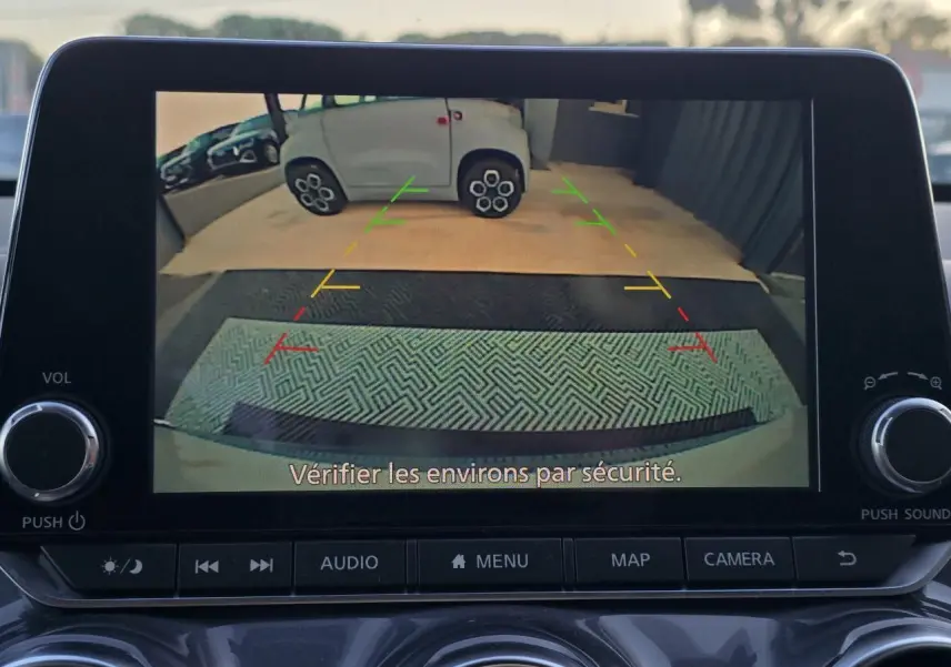 Écran de caméra de recul du Nissan Juke II bleu magnetic montrant l'arrière avec lignes de guidage colorées.