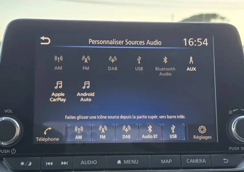 Écran tactile du système audio du Nissan Juke II bleu magnetic, affichant les options de sources audio.
