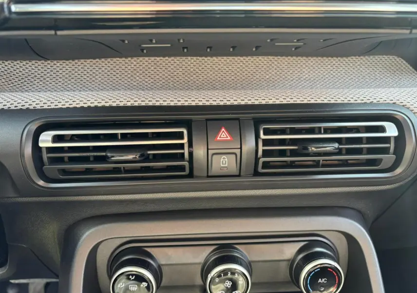 Détail de la console centrale avec aérateurs et commandes de climatisation d'une Citroën C3 Rouge Elixir toit noir.