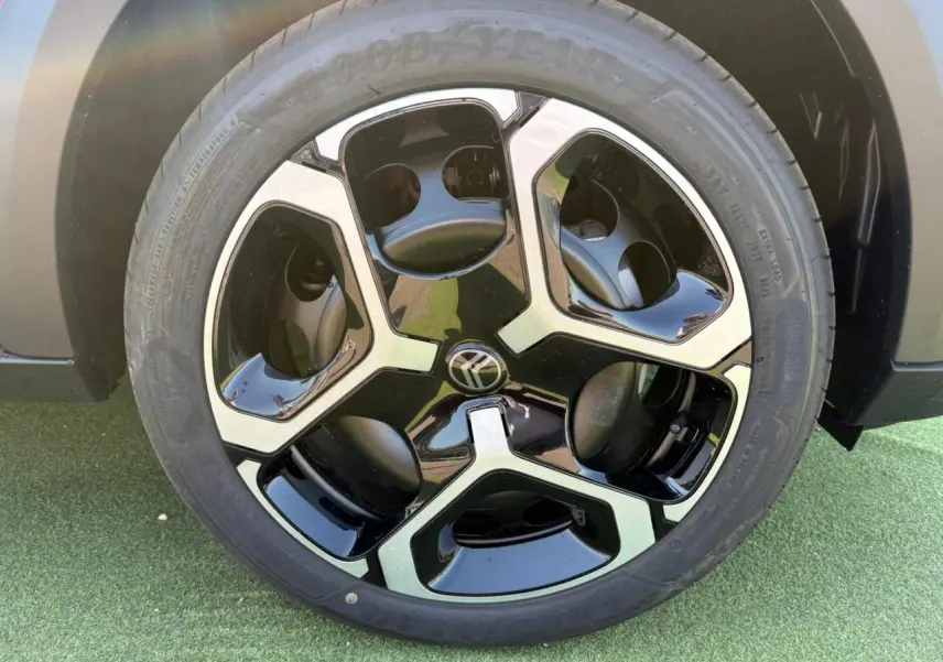 Gros plan sur la jante noire et argentée du côté gauche d'une Citroën C3 Rouge Elixir toit noir 2025.