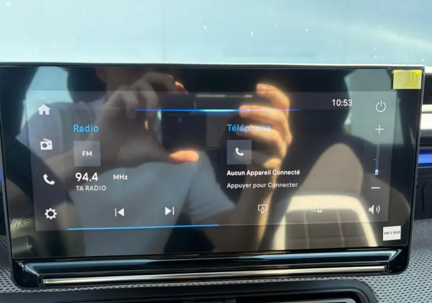 Écran tactile central de la planche de bord de la Citroën C3 IV rouge Elixir avec toit noir, affichant la radio et téléphone.