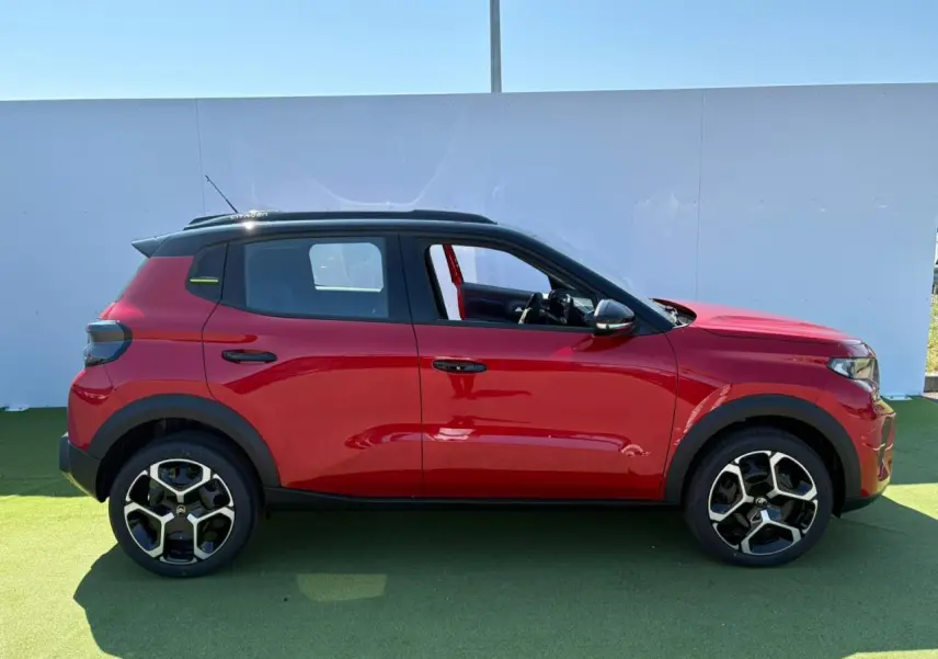 Profil côté gauche d'une Citroën C3 2025 rouge Elixir avec toit noir et jantes 17 pouces AZURITE.
