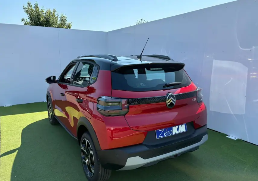 Vue 3/4 arrière droite d'une Citroën C3 2025 rouge Elixir avec toit noir et jantes 17 pouces Azurite.