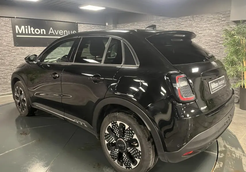 Vue 3/4 arrière droite d'une FIAT 600 noire avec jantes alliage 18'' diamantées et feux arrière LED distinctifs.