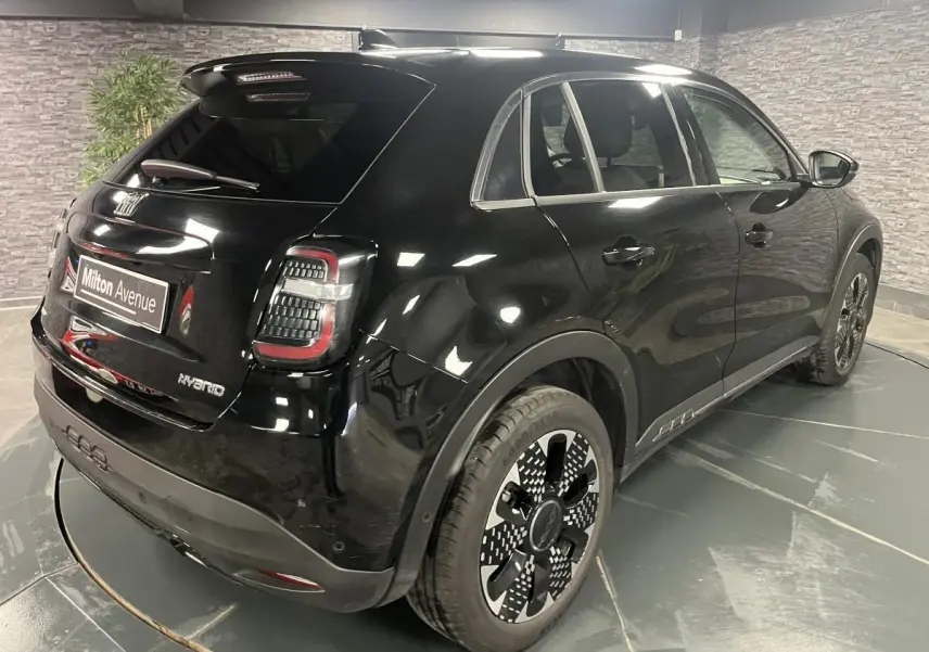 Vue 3/4 arrière droite d'une FIAT 600 hybride noire avec jantes alliage diamantées et feux arrière LED distinctifs.