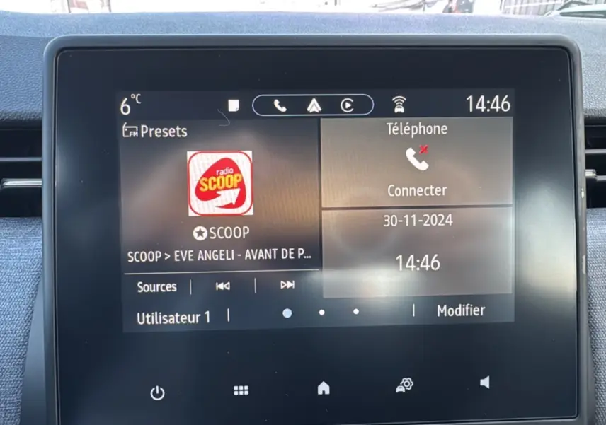 Écran tactile central de la Renault Clio 2025 affichant la radio et la connexion téléphone, intérieur noir.