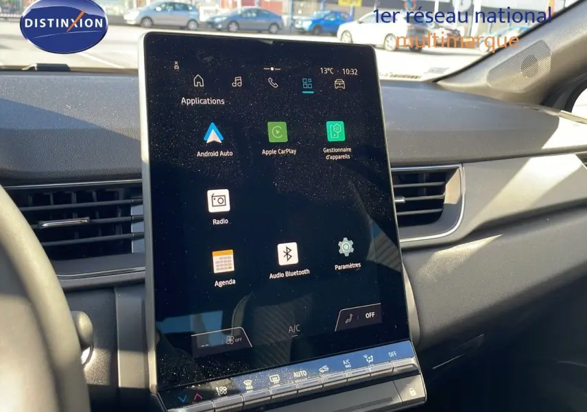 Écran tactile central allumé dans l'habitacle du Renault Captur gris rafale métal, vue de face côté passager.