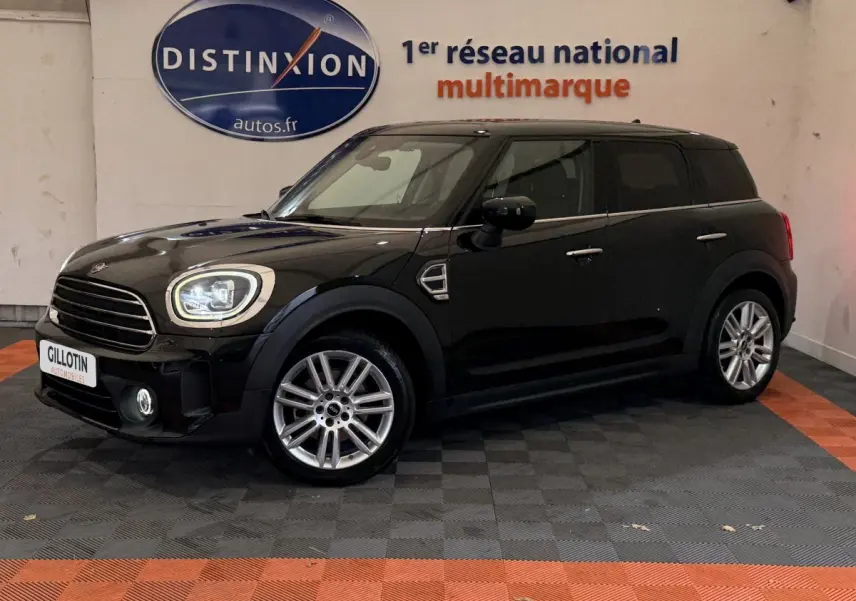 MINI Countryman noir vue de profil côté gauche en intérieur, avec jantes alliage et phares LED allumés.