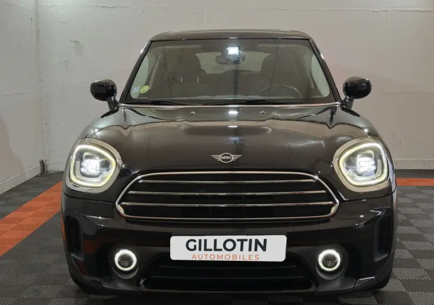 Vue frontale d'un MINI Countryman Cooper D Business Design noir avec phares LED allumés et calandre chromée.