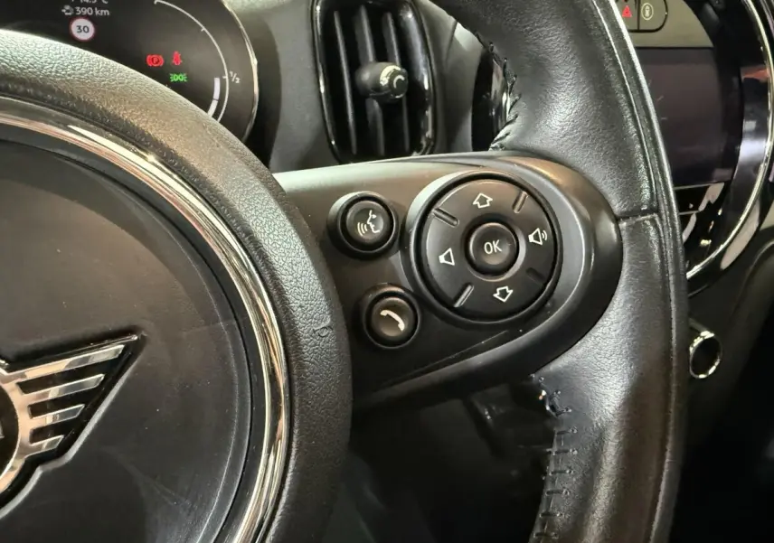 Gros plan sur le volant cuir noir de la MINI Countryman 2020, avec commandes vocales et multimédia visibles côté droit.