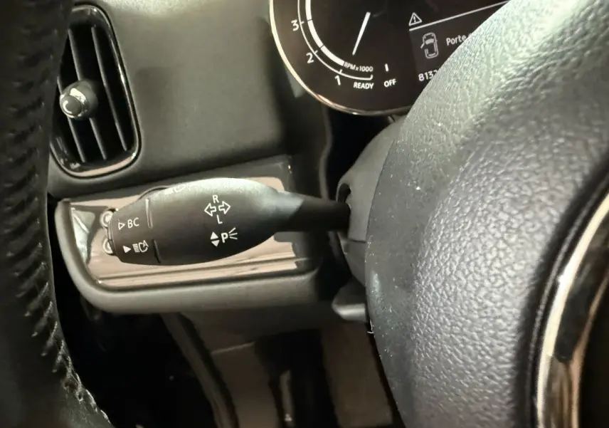 Gros plan sur la manette de clignotants à gauche du volant cuir dans l'habitacle noir du MINI Countryman 2020.