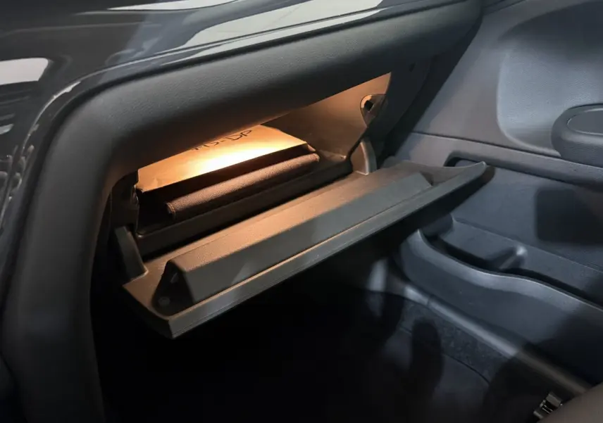 Gros plan sur la boîte à gants ouverte avec éclairage intérieur dans le MINI Countryman Cooper D Business Design 2020.