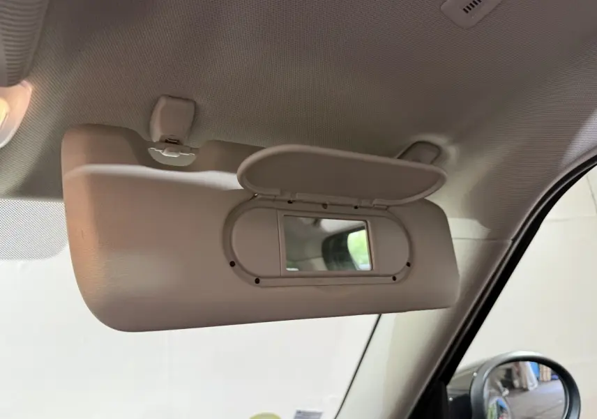 Miroir de courtoisie ouvert côté conducteur dans l'habitacle d'une MINI Countryman noire, vue intérieure rapprochée.