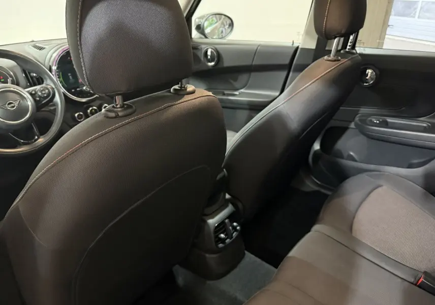Vue intérieure arrière droite du MINI Countryman noir 2020, montrant les sièges avant et arrière en tissu et cuir.