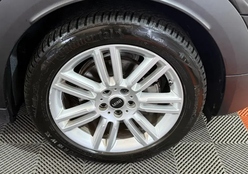 Gros plan sur la roue avant droite avec jante argentée et logo MINI du MINI COUNTRYMAN noir 2020.