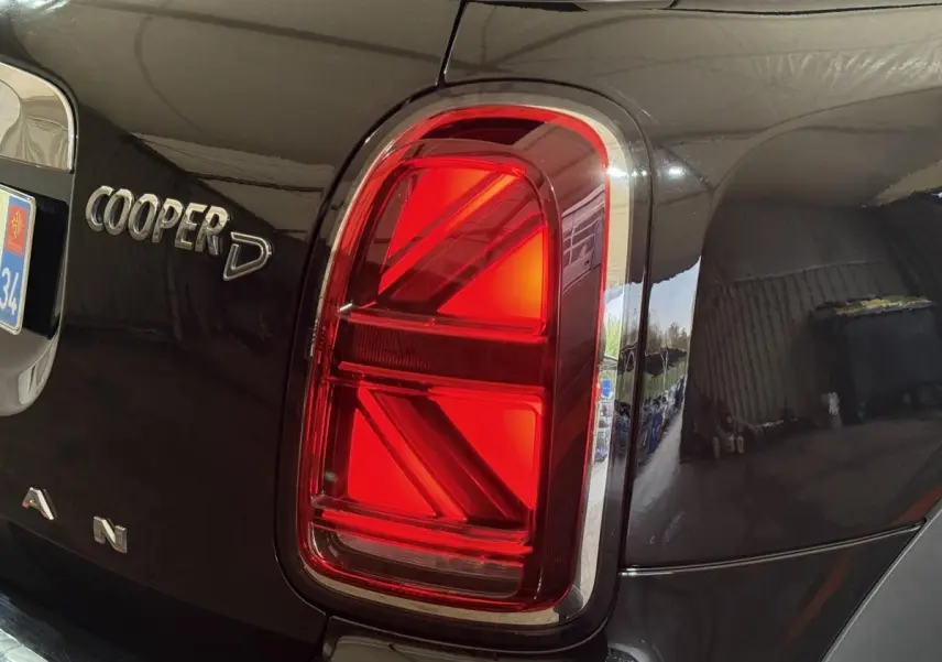 Gros plan sur le feu arrière droit rouge et l’inscription Cooper D du MINI Countryman noir 2020.