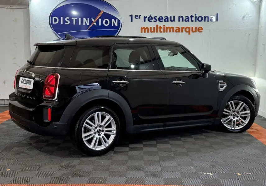 Vue de profil côté gauche d'une MINI Countryman Cooper D Business Design noire, avec jantes alliage et vitres teintées.