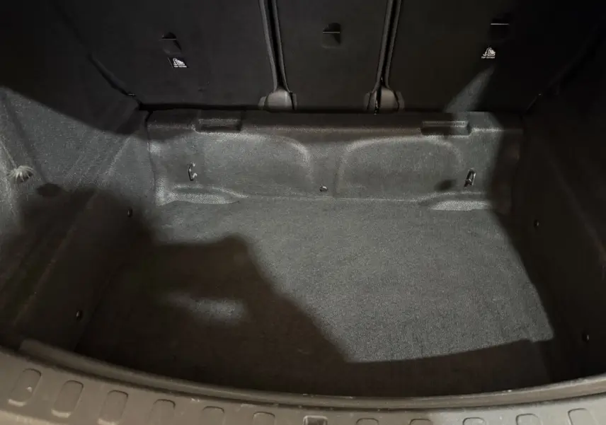 Vue intérieure du coffre noir du MINI COUNTRYMAN Cooper D Business Design 2020, montrant l'espace de chargement vide et les dossiers arrière rabattus.