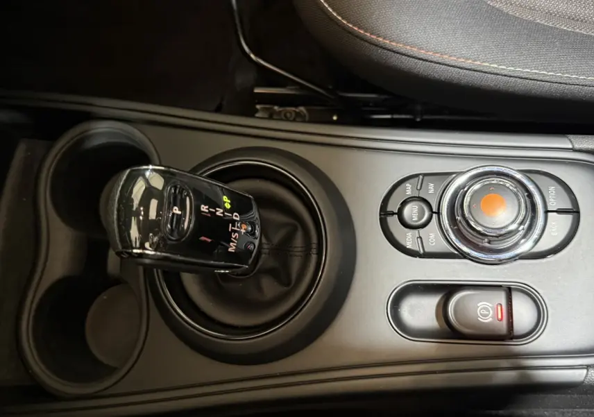 Gros plan sur la console centrale noire du MINI Countryman Cooper D 2020 avec levier de vitesses automatique et molette de contrôle.