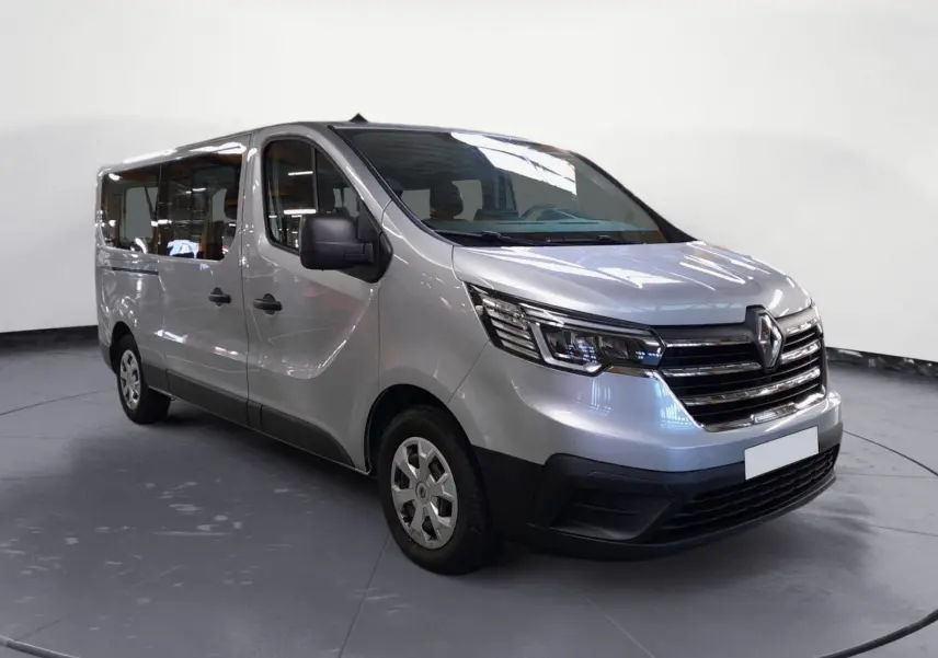 Renault Trafic Combi gris Highland en vue 3/4 avant droit, mettant en valeur ses grandes vitres latérales et sa calandre chromée.