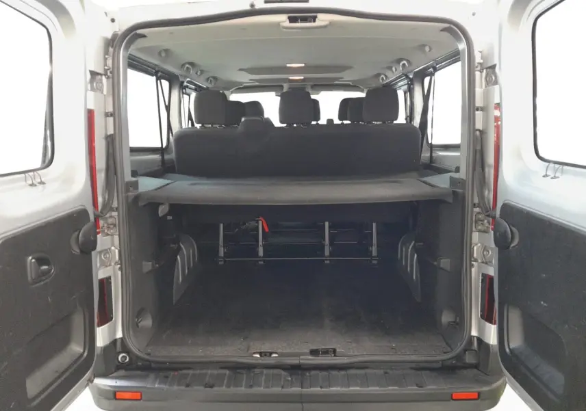 Vue arrière ouverte du Renault Trafic Combi gris Highland montrant l'espace de chargement et les sièges passagers.