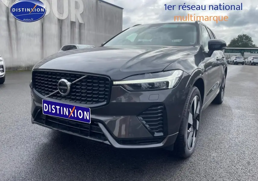 Vue 3/4 avant droite du Volvo XC60 gris métallisé avec calandre noire et jantes alu distinctives.