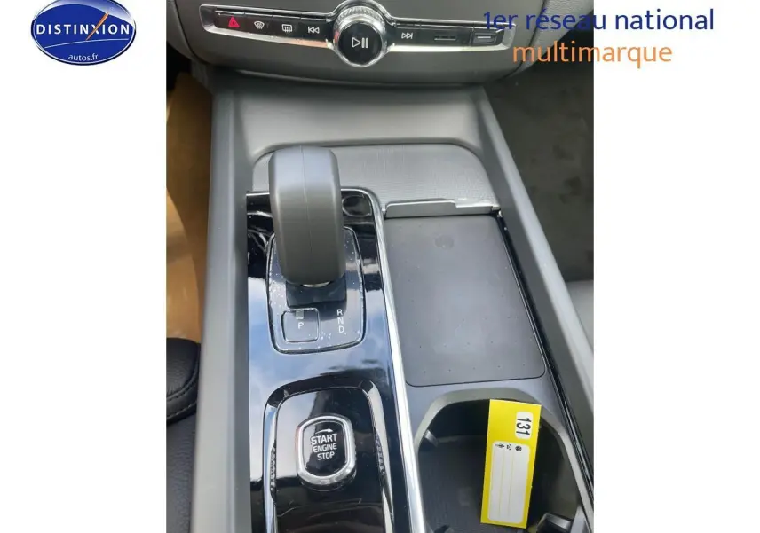 Gros plan sur la console centrale du Volvo XC60 gris 2024, avec levier de vitesse et bouton start/stop.