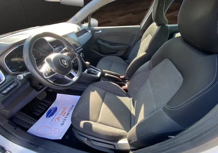 Vue intérieure côté conducteur de la Renault Clio V E-Tech 140 Business, sièges tissu noir et tableau de bord moderne.