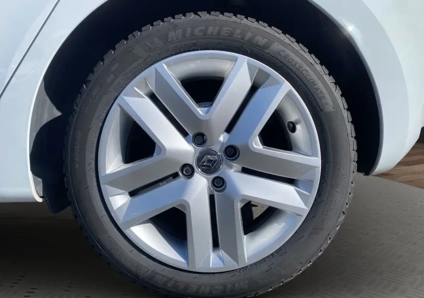 Gros plan sur la roue avant droite d’une Renault Clio V blanche, avec jante alliage argentée et pneu Michelin.