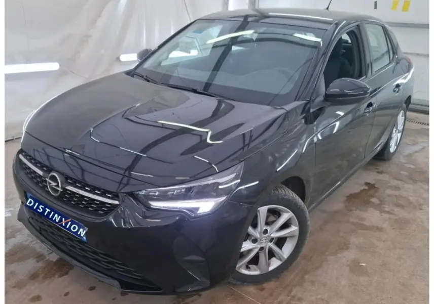 Vue 3/4 avant droite d'une Opel Corsa 2023 noir perla avec phares allumés et jantes alliage visibles.