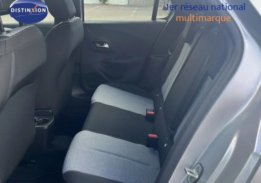 Vue côté droit de l’arrière de l’Opel Corsa gris 2025, montrant les sièges bicolores en tissu et la portière ouverte.