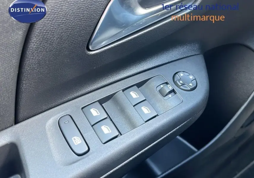 Gros plan sur les commandes électriques des vitres et rétroviseurs côté conducteur d’une Opel Corsa gris 2025.