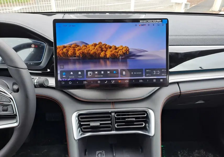 Vue intérieure frontale du tableau de bord noir avec écran tactile 15,6'' et surpiqûres orange du BYD SEAL U 2025.