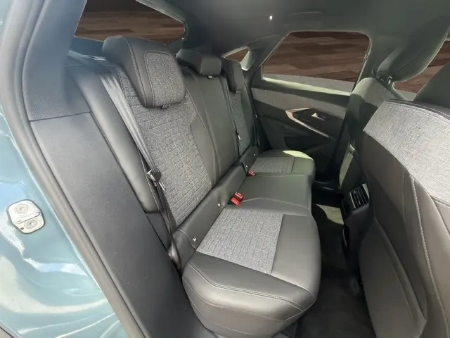 Vue intérieure arrière gauche du Peugeot 3008 bleu 2025, sièges arrière en tissu et cuir bicolore avec appuie-têtes.