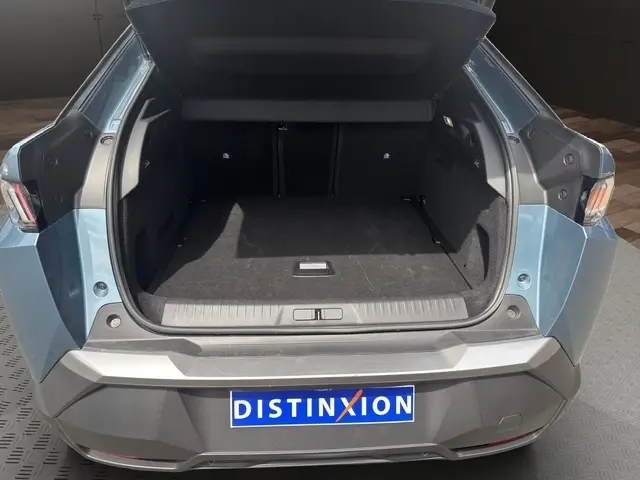 Coffre ouvert en vue arrière d’un Peugeot 3008 bleu 2025, montrant l’espace de chargement et la plaque Distinxion.