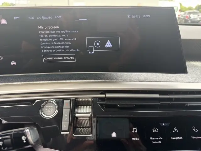Vue rapprochée du tableau de bord du Peugeot 3008 bleu 2025, avec écran tactile multifonctions et bouton démarrage visible.