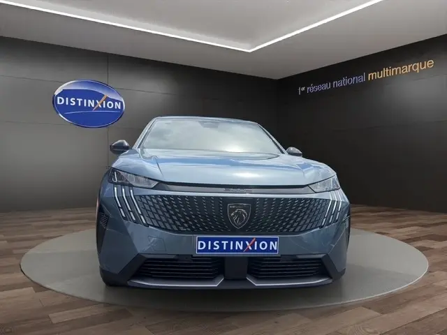 Vue de face du Peugeot 3008 bleu 2025 avec calandre distinctive et phares LED, présenté en showroom.