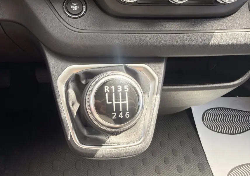 Gros plan sur le levier de vitesses manuel noir du Renault Trafic Fourgon 2025, entouré de garniture grise.