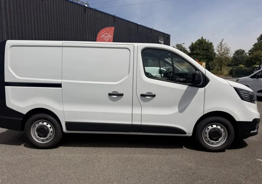 Renault Trafic Fourgon blanc vu de profil côté droit, avec portes latérales pleines et jantes acier grises.