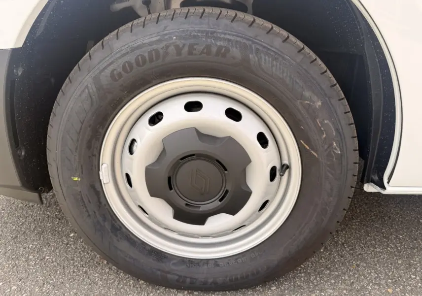 Gros plan sur la roue avant droite du Renault Trafic blanc, jante acier avec logo Renault central.