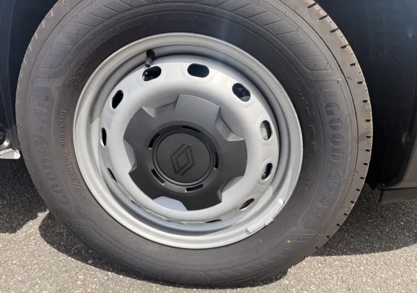 Gros plan sur la roue avant droite du Renault Trafic Fourgon blanc, jante acier avec logo Renault central noir.