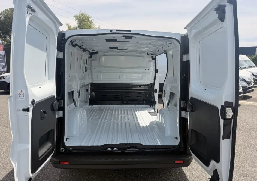 Vue arrière du Renault Trafic Fourgon blanc 2025 avec portes ouvertes montrant l'espace de chargement vide et spacieux.