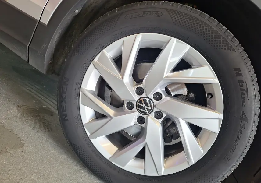 Gros plan sur la jante alliage 18'' Francfort argentée avec logo Volkswagen du Tiguan gris côté avant droit.